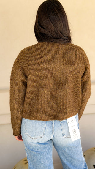 Back view of olive brown ribbed knit cardigan sweater with long sleeves, worn with light wash jeans