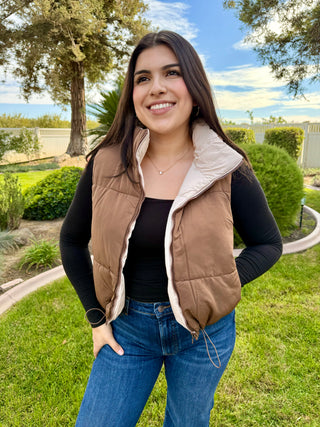 A woman wearing a reversible puffer vest with pockets. 